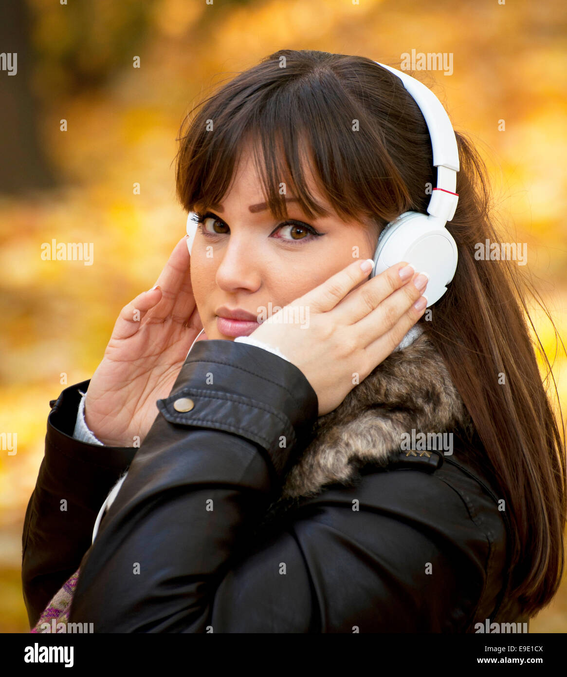 Portrait of a beautiful girl listening to music in autumn park Stock ...
