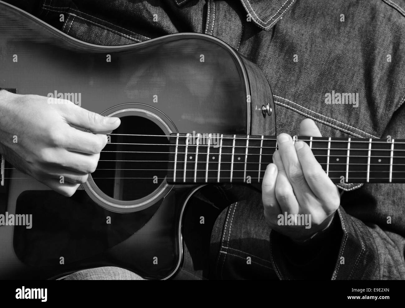 Close up of male hands playing guitar in black and white Stock Photo