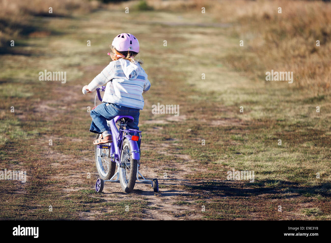 Small funny kid riding bike with training wheels Stock Photo Alamy