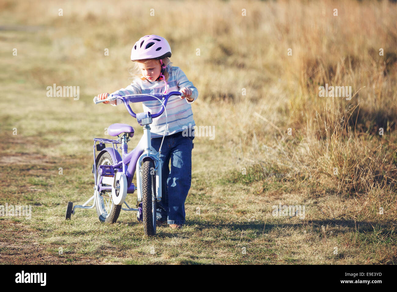 Small funny kid riding bike with training wheels Stock Photo Alamy