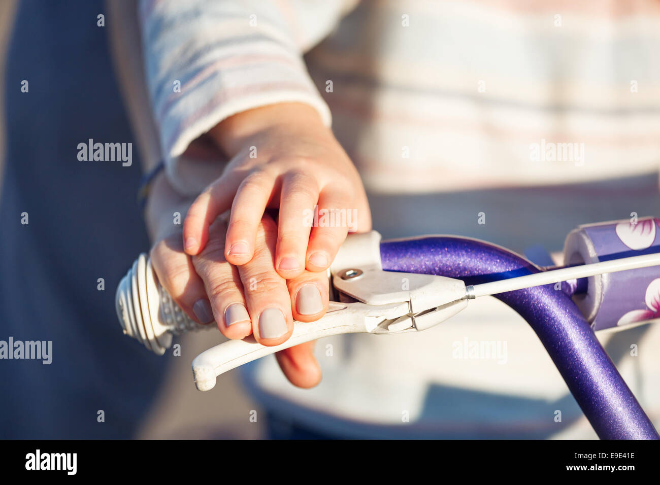 Child with parent learning riding bike hands closeup Stock Photo Alamy