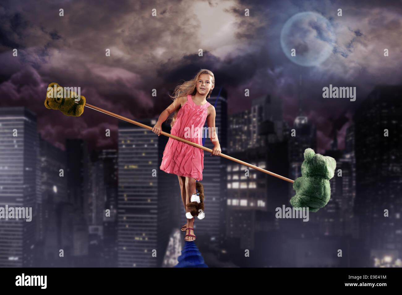 a teenage girl as a tightrope walker over the night town Stock Photo