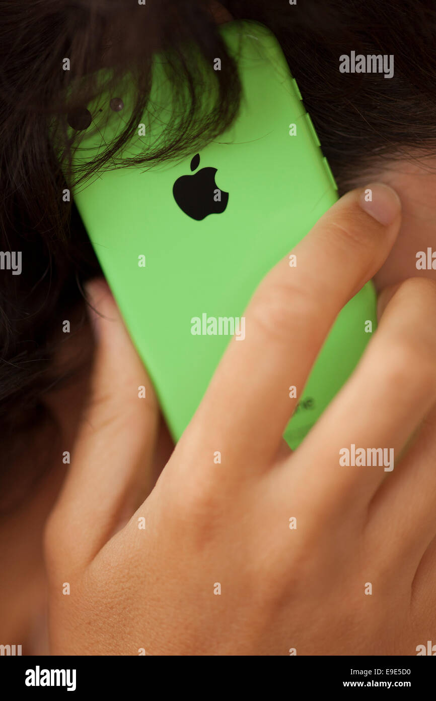 Paphos, Cyprus - November 11, 2013 Woman's hand with Apple iPhone 5C Green Color. Woman is using an iPhone to call. Stock Photo