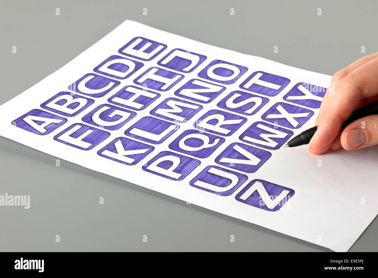 Woman's hand with ballpoint pen draw alphabet with letters' blue