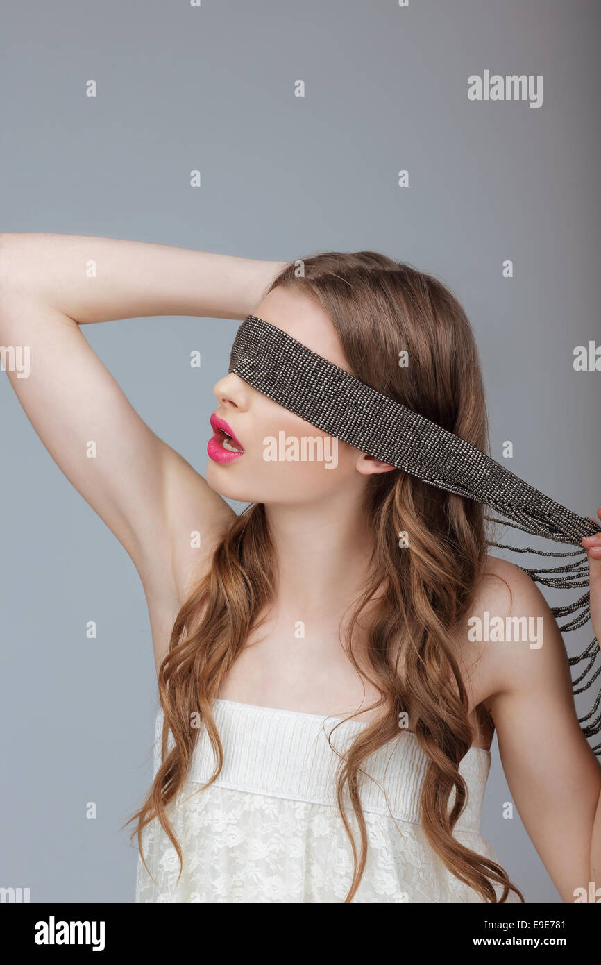 Hide and Seek. Woman Holding a Strap on her Face. Puzzle Stock Photo