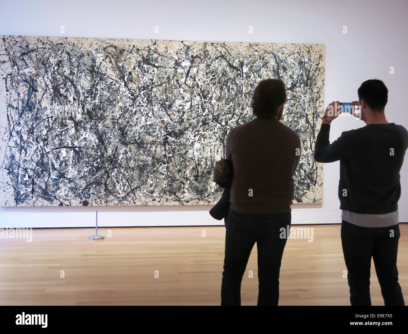 Visitors Admiring and Taking Photos of a Jackson Pollock Drip Painting, Museum of Modern Art, NYC Stock Photo