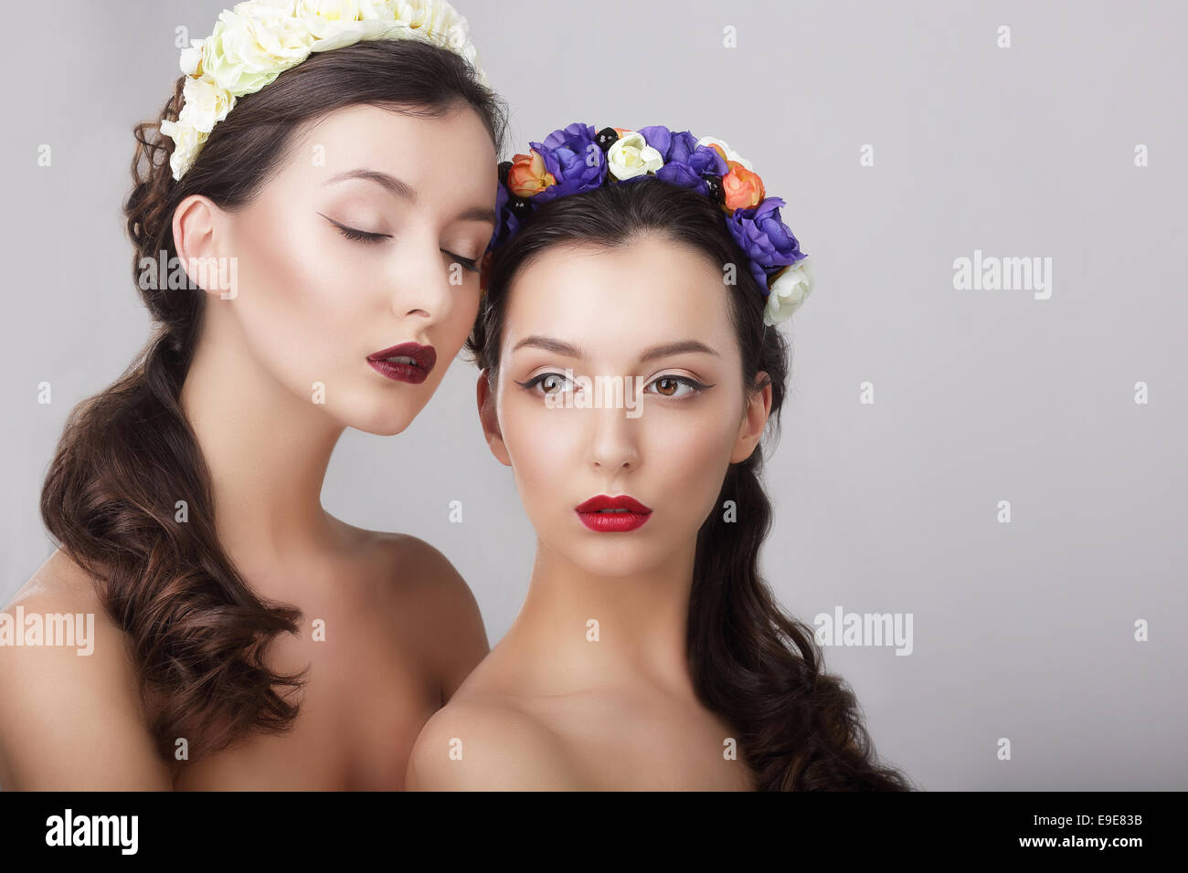 Sentiment. Glamor. Gorgeous Women in Wreaths of Flowers Stock Photo