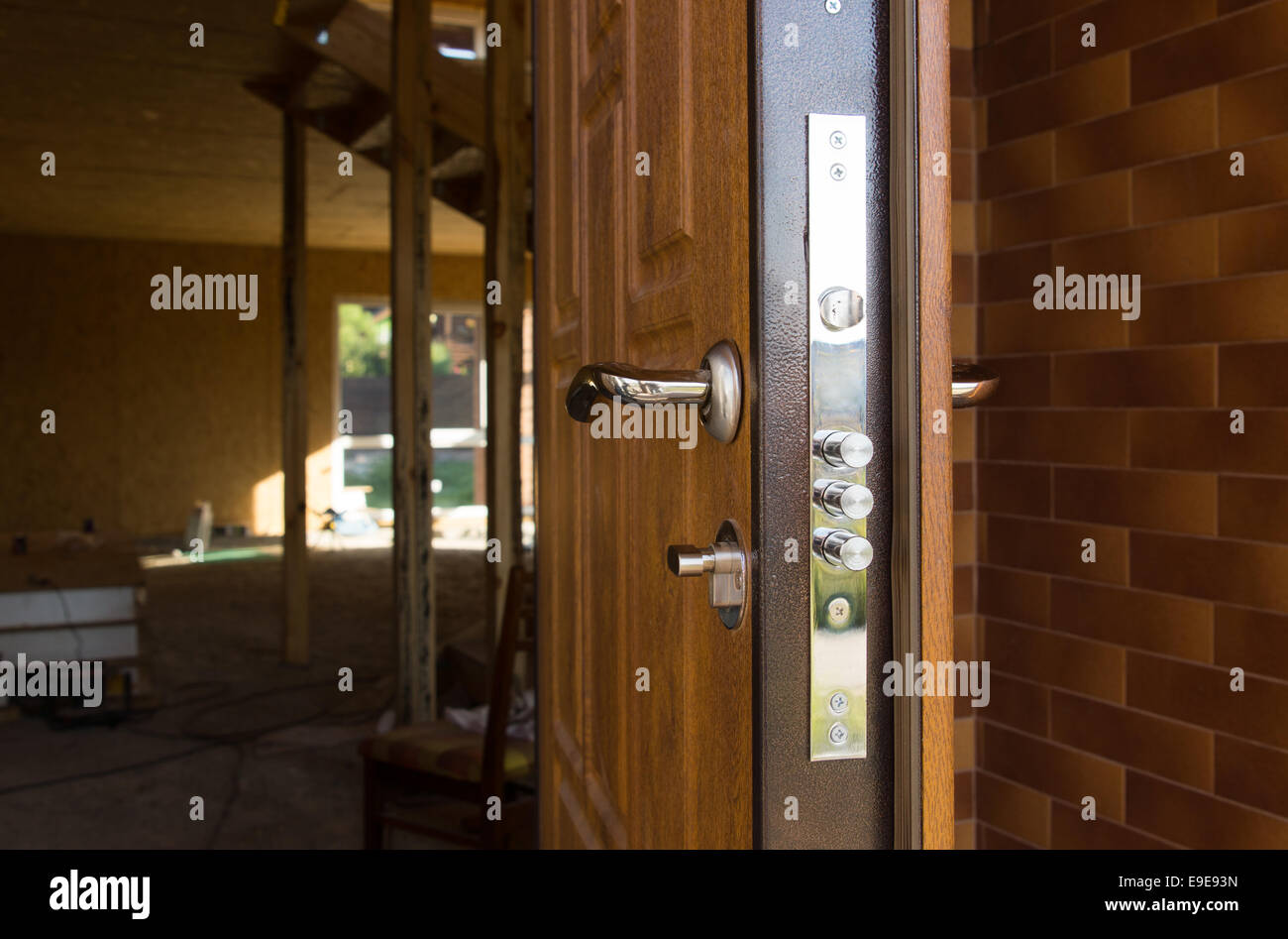 Safety lock on a new wooden front door showing the three security