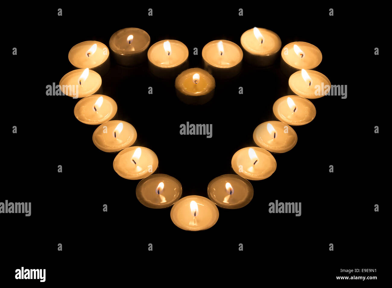 Tea Candles forming a heart shape on black background Stock Photo Alamy