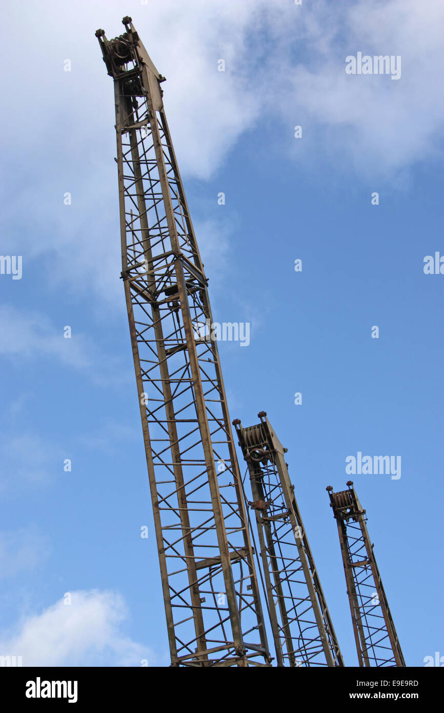 The Jibs of Three Vintage Cranes in a Line. Stock Photo