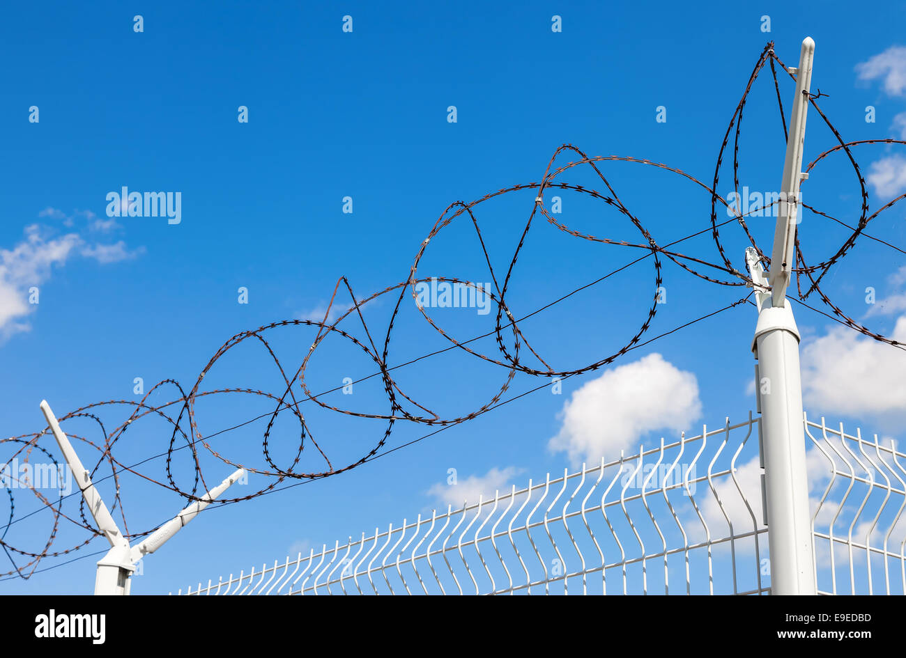 Barbed wire on blue sky background Stock Photo - Alamy