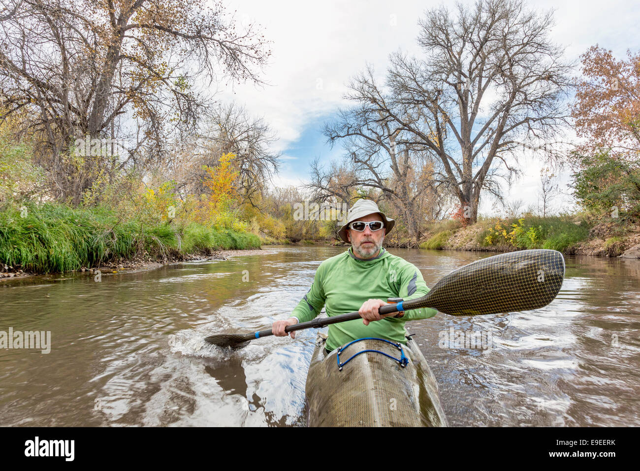 senior male paddler training in a fast sea kayak used in adventure racing, fall scenery, Poudre RIver in Fort Collins, Colorado Stock Photo