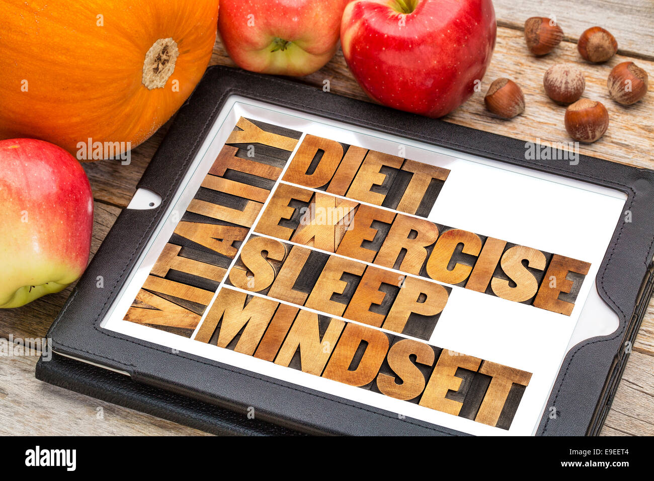 diet, sleep, exercise and mindset - vitality concept - abstract in vintage letterpress wood type on a digital tablet with apples Stock Photo