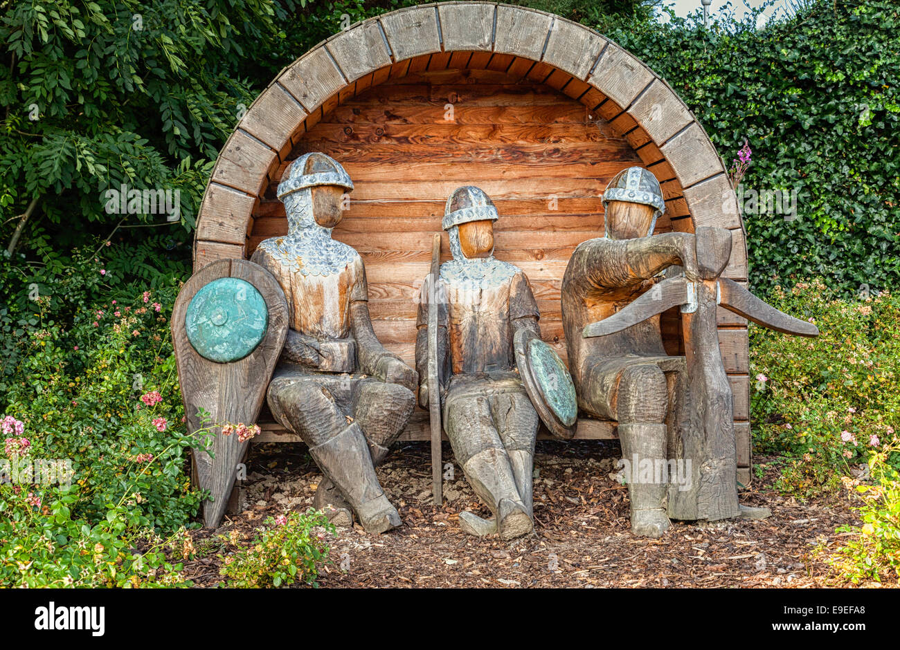 Rhuddlan Denbighshire North Wales UK. Three faceless carved wooden Norman medieval soldiers seated in relaxed pose Stock Photo