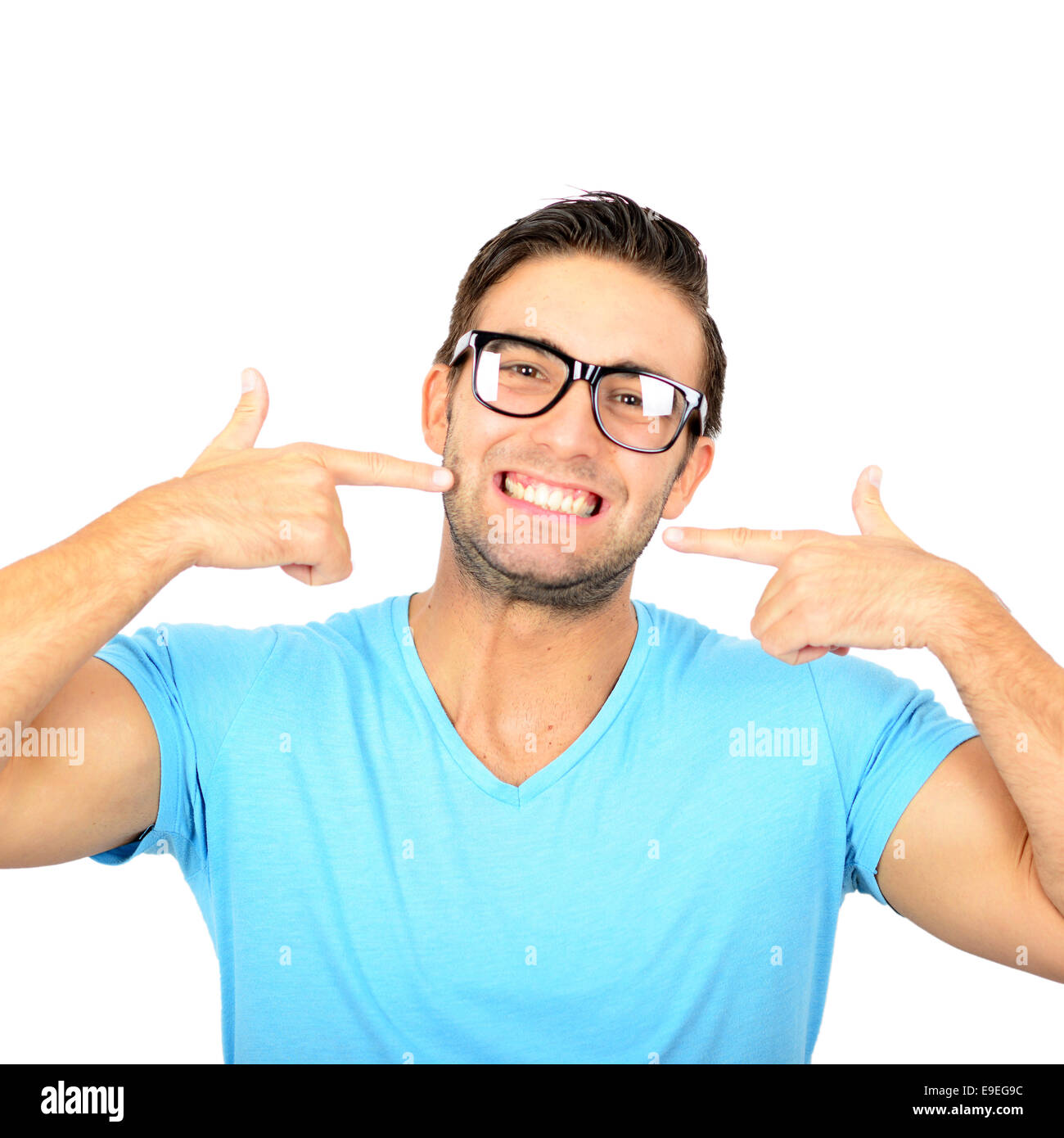 Portrait of handsome man poitning at his healthy smile or teeth against white background Stock Photo