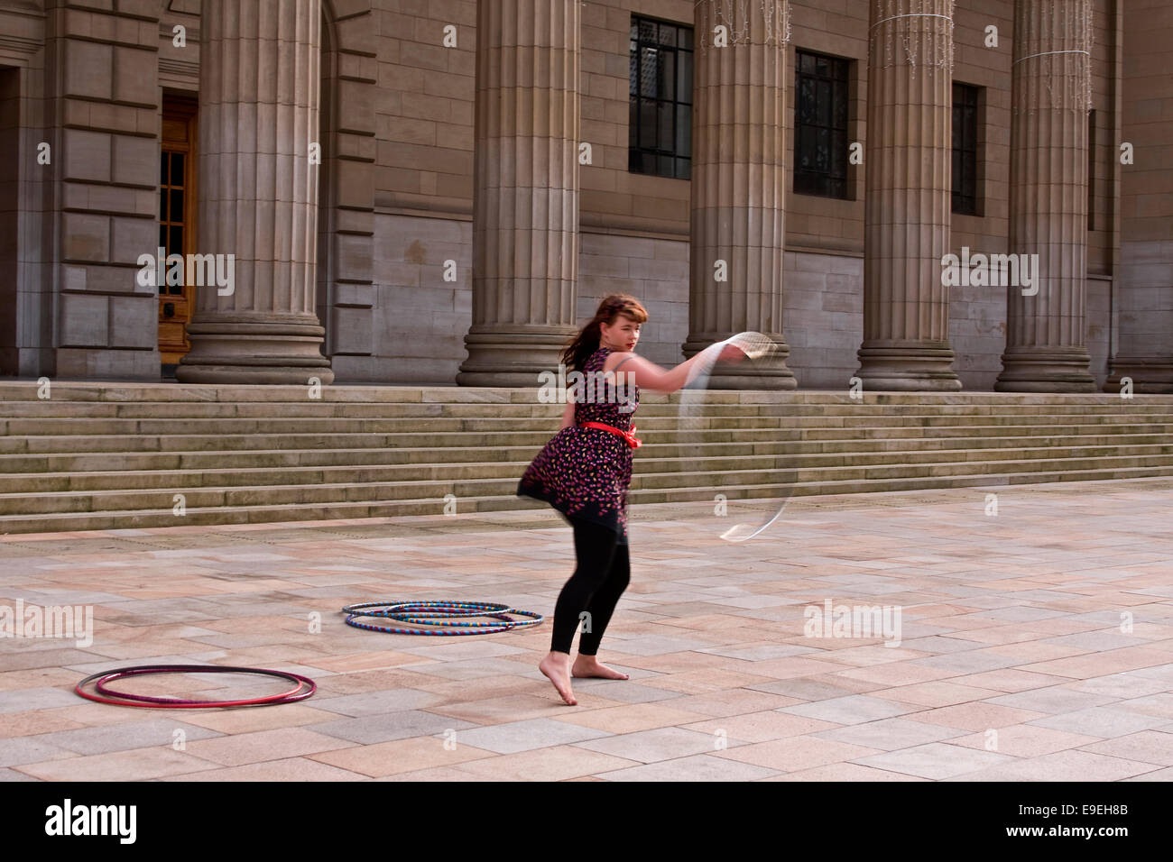 Claire Nicoll Hula Hoop dancing on a cold and windy October afternoon at the front entrance of the Caird Hall in Dundee, UK Stock Photo
