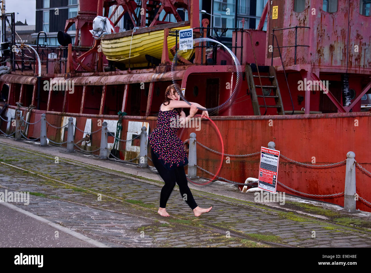 Claire Nicoll Hula Hoop dancing on a windy October afternoon beside the North Carr Lightship at the Victoria Docks in Dundee, UK Stock Photo