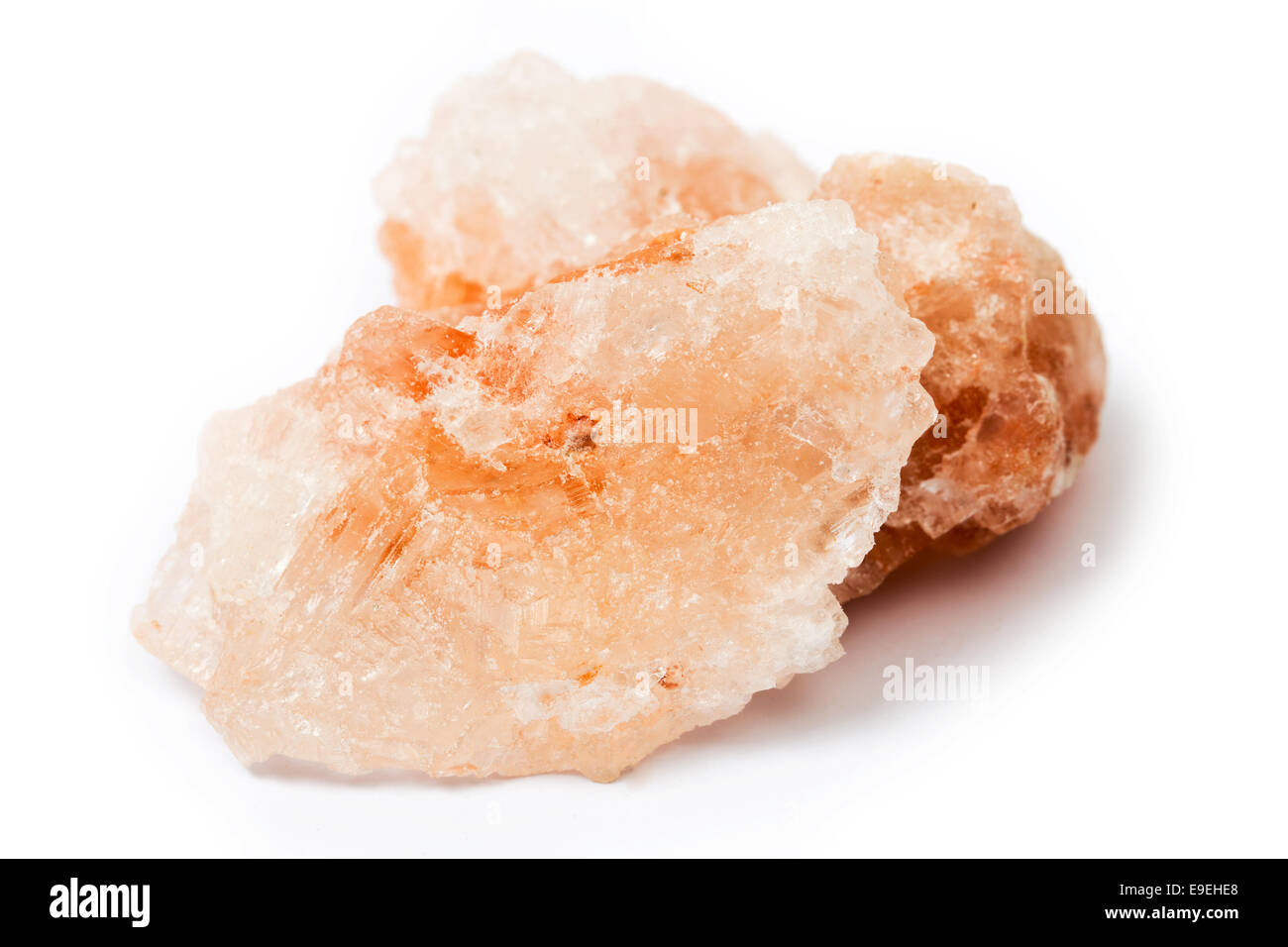 Crystalline Himalayan pink rock salt over a white background Stock Photo