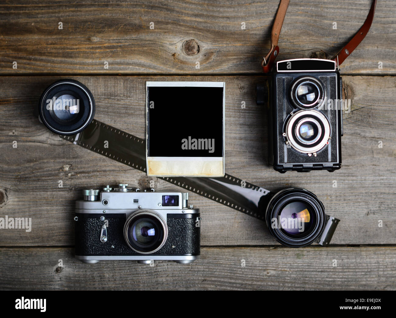 Vintage cameras with lenses and blank old photograph on wooden ...