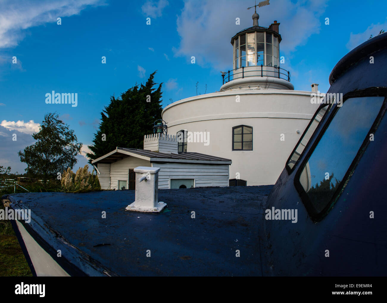 Usk Lighthouse , Wales, Uk. A light house stands beyond the boat against a blue sky. Stock Photo