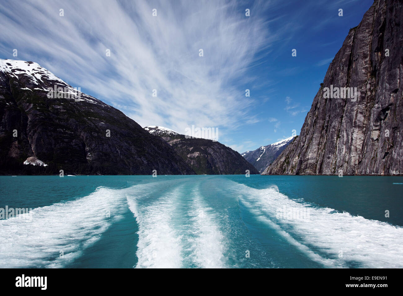 Sheer-walled mountains rise above boat wake in Tracy Arm, Southeast Alaska, USA Stock Photo