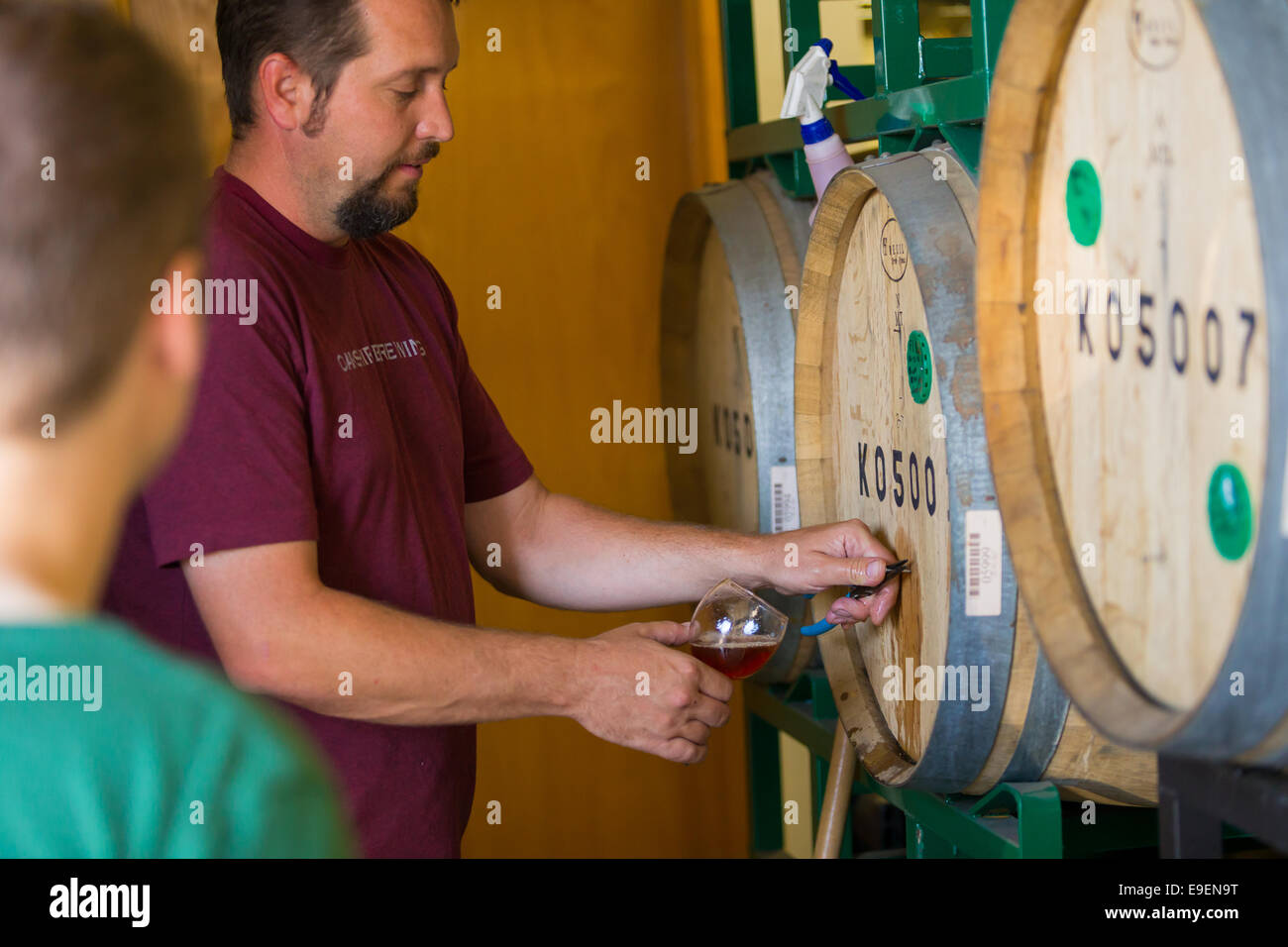 Eugene, OR, USA - July 17, 2014: Master brewer and employee sampling and tasting limited edition bourbon barrel aged beers at Oa Stock Photo