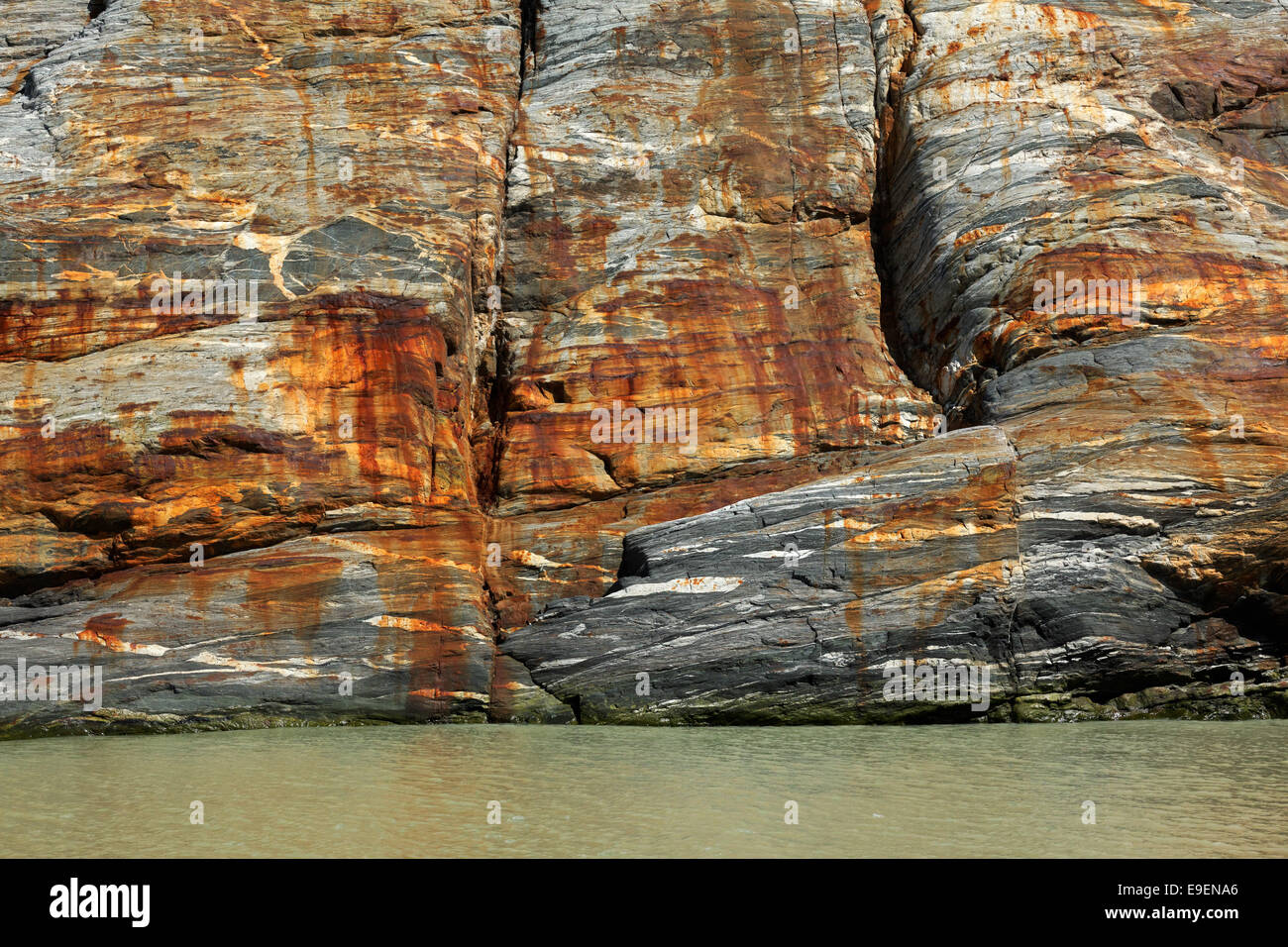 Rusty face of glacial-carved rock cliff face, Tracy Arm, Southeast Alaska, USA Stock Photo