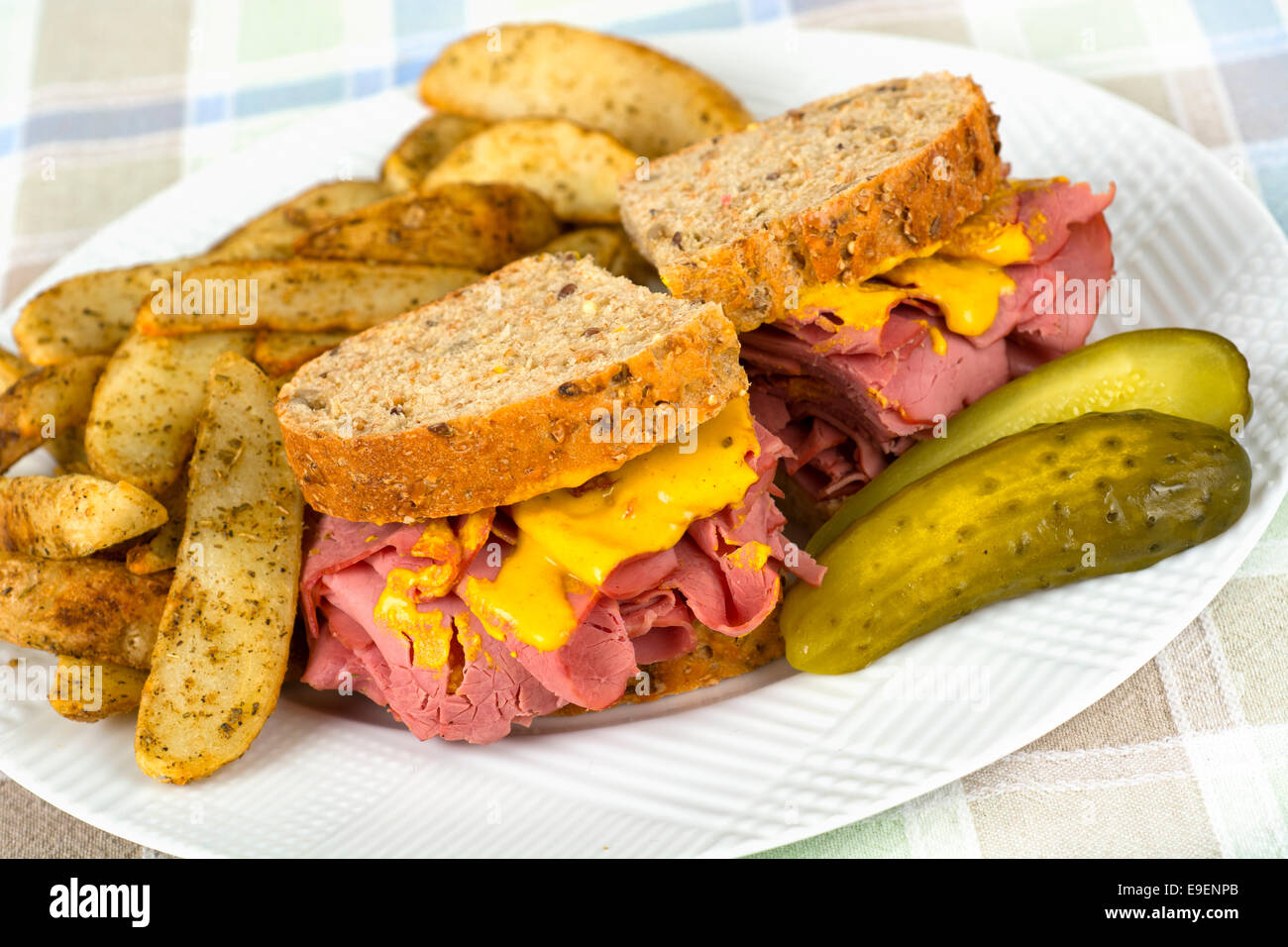 Corned Beef Sandwich Mustard Roasted Potatoes and Pickle on Plate Stock