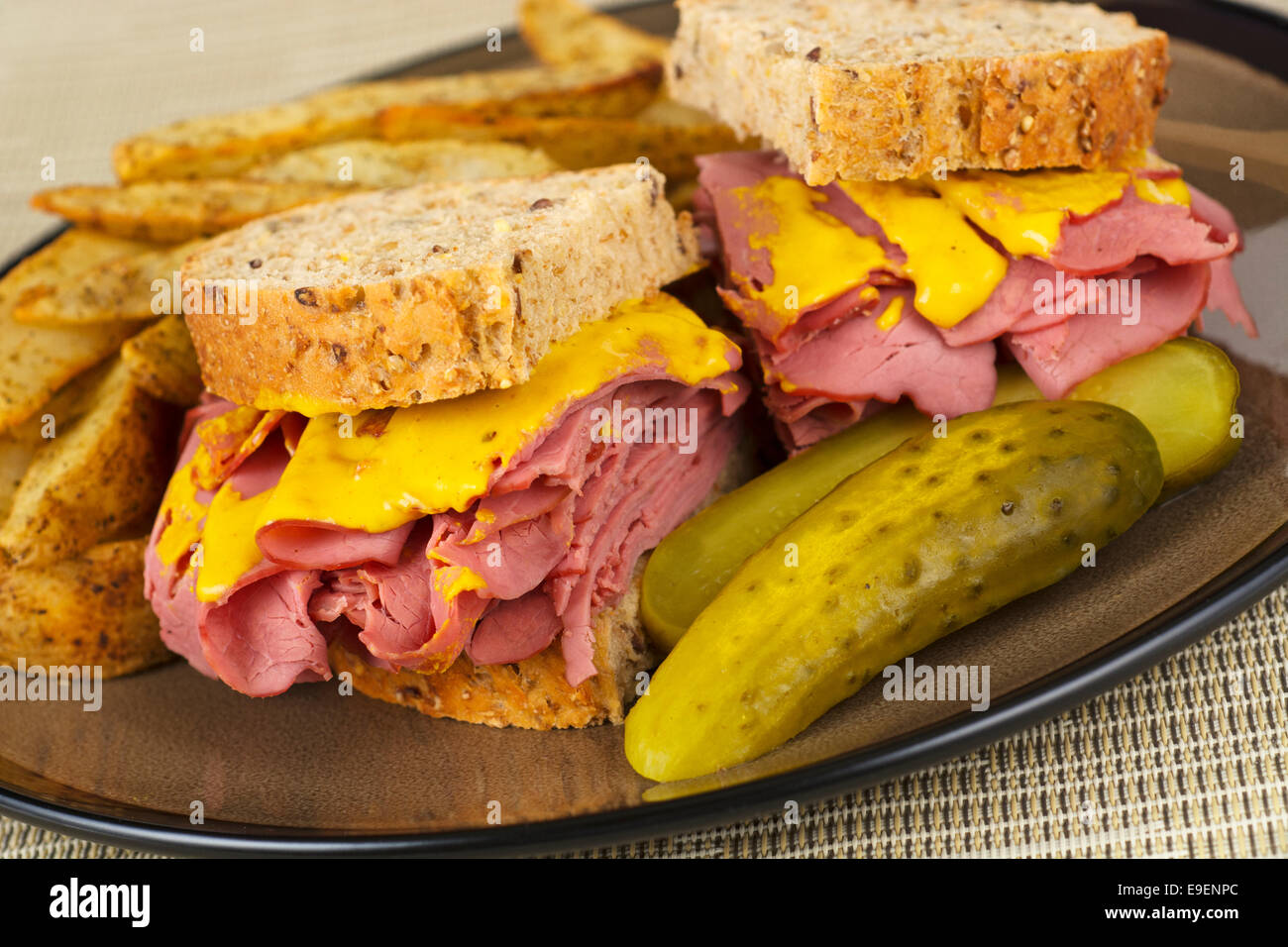 Corned Beef Sandwich Mustard Roasted Potatoes and Pickle on Plate Stock