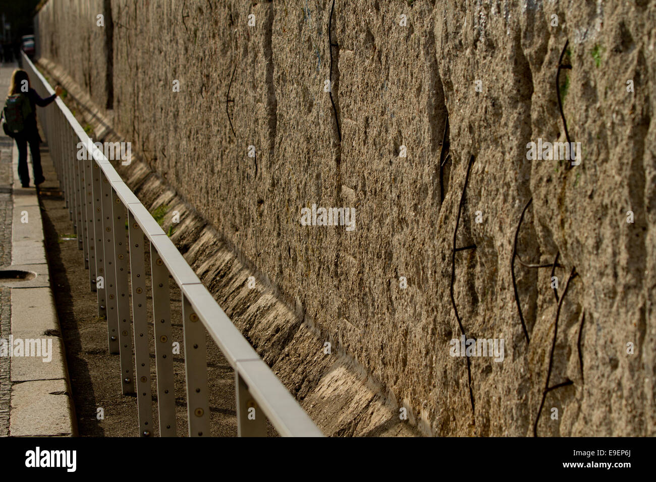 Berlin Wall railing person looking exposed stone Stock Photo
