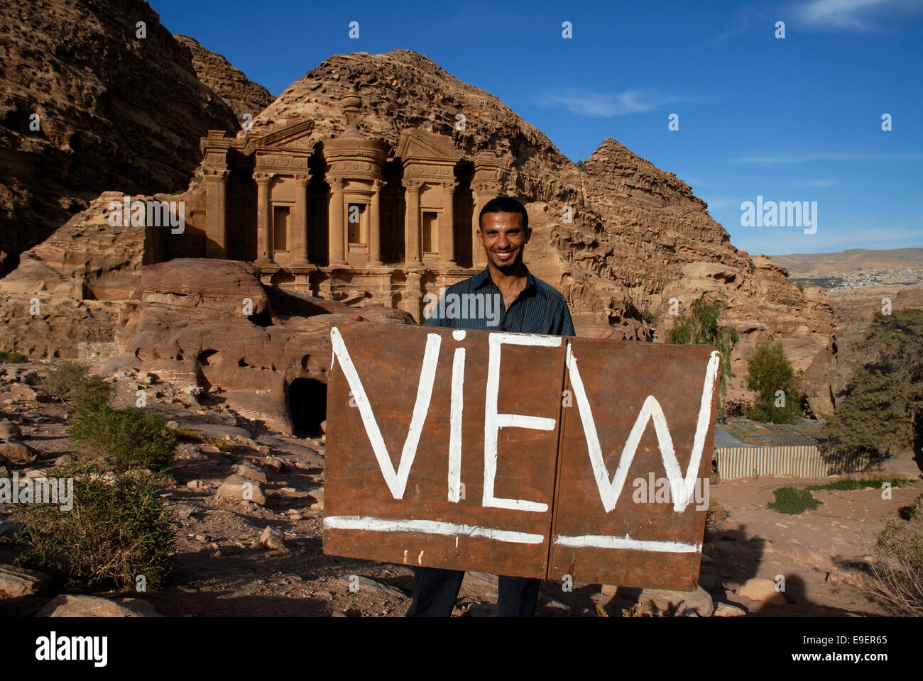 Man with a sign of View at Al Dair, The Monastery, Petra, Archaeological Site, World Heritage UNESCO, Jordan, Middle East Stock Photo