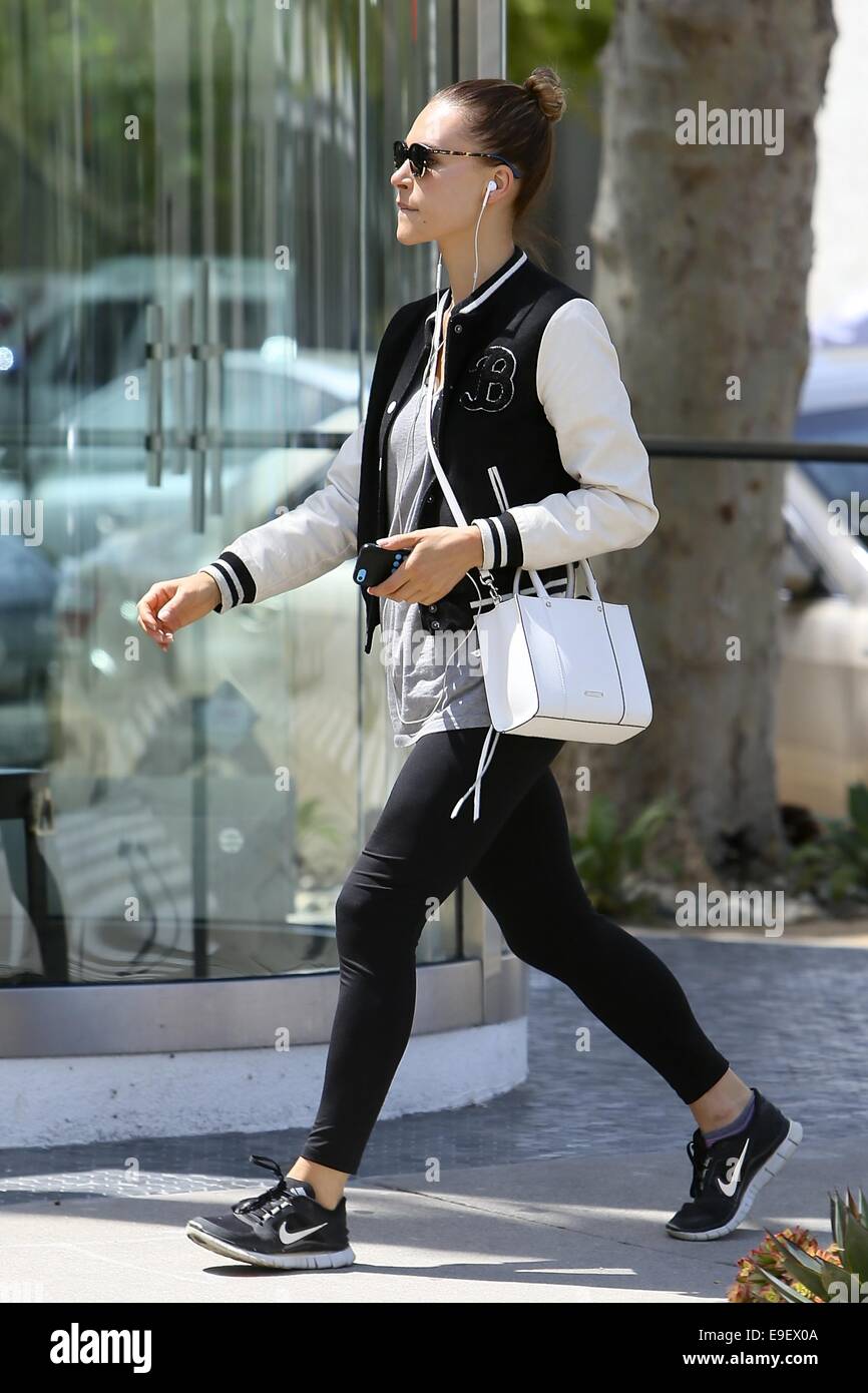 Sunglasses Varsity Jacket Black leggings Nike Trainers Head Phones iPhone  White bag with shoulder strap Grey T Shirt Hair in a bun paparazzi Stock  Photo - Alamy