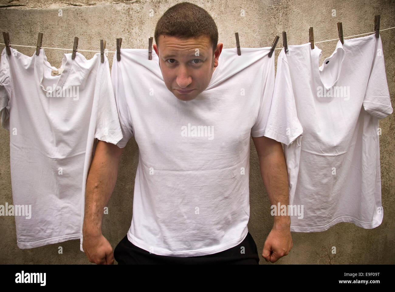 a man pinned on a washing line with white t-shirts Stock Photo