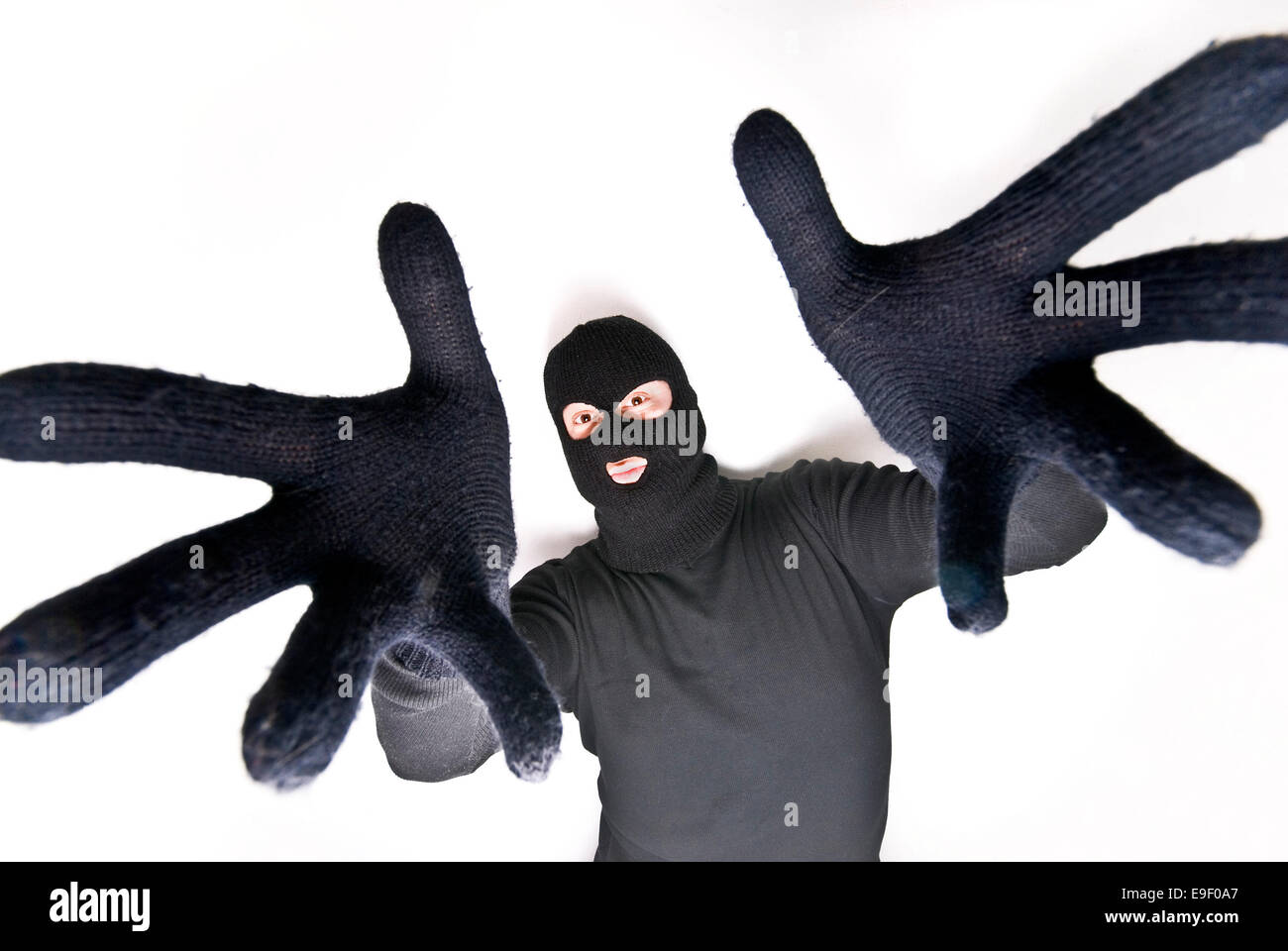 a man with a balaclava and dressed all in black with black gloves pulls