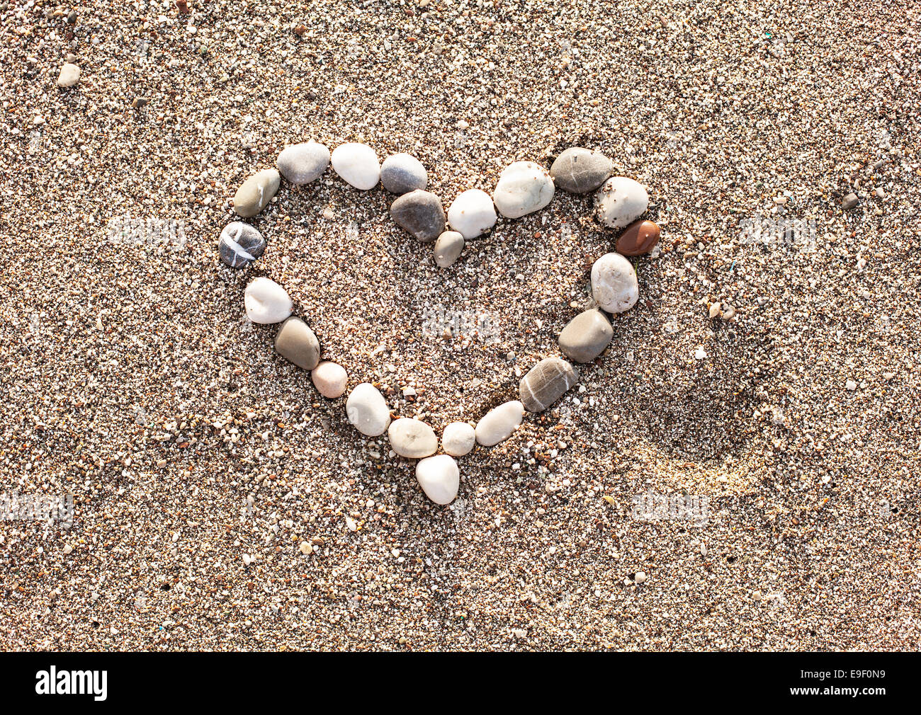 Heart of marine shingles on the sand. Stock Photo