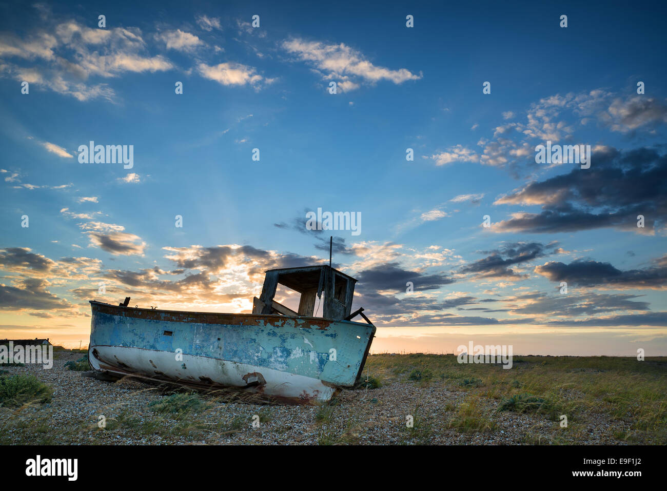 Abandoned fishing boat on shingle beach landscape at sunset Stock Photo ...