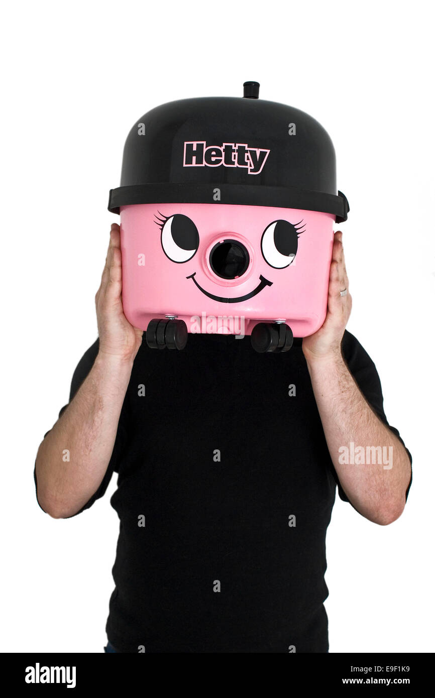 a man holds up a pink hetty hoover / cleaner over his face Stock Photo