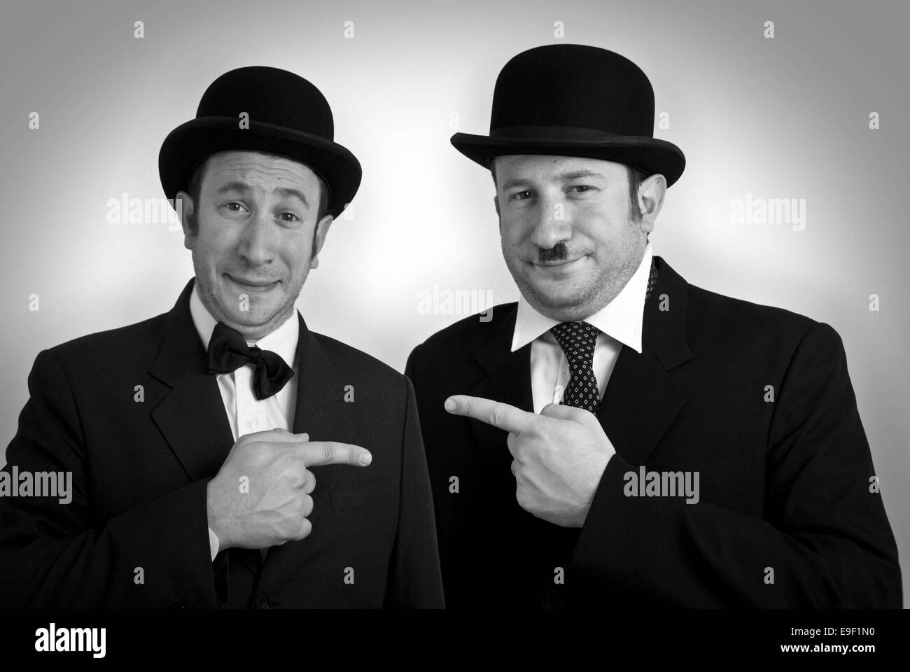 a man dressed as Laurel & Hardy with bowler hats and photoshopped face Stock Photo