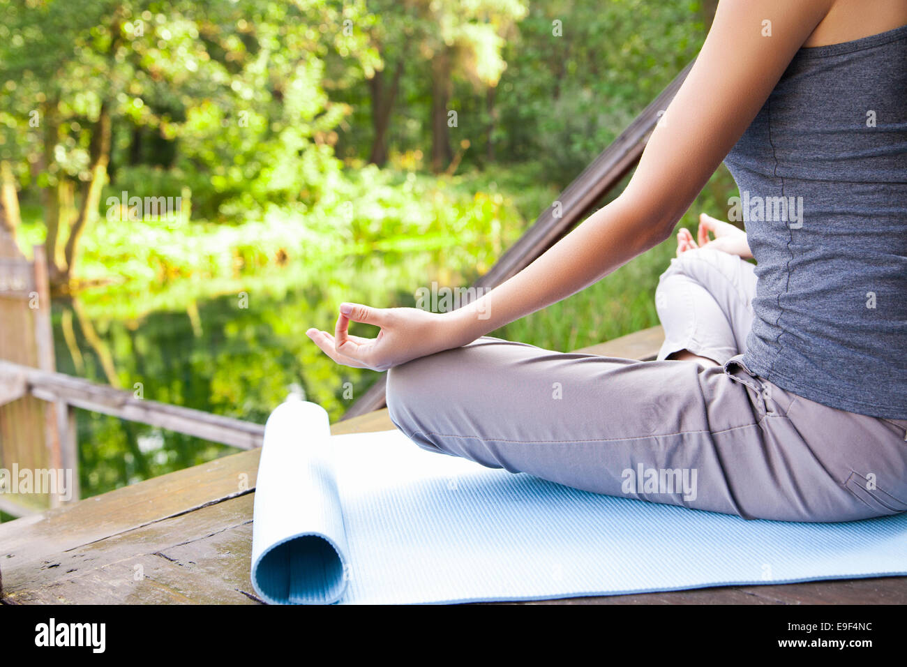 Young girl doing yoga lotus pose in the park Stock Photo - Alamy