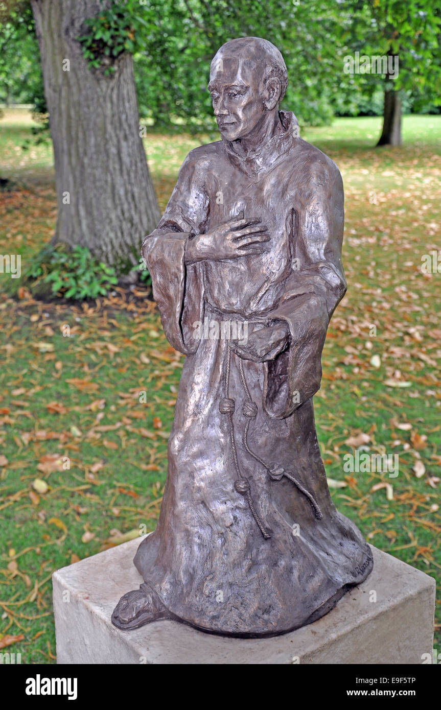 Bronze monk sculpture/statue on plinth, on display outdoors as a large garden ornament. England, UK. Stock Photo