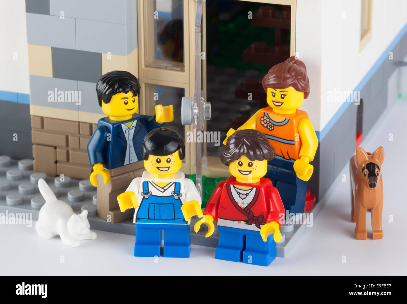 Tambov, Russian Federation - January 12, 2014 Happy LEGO family standing near his home with pets. Stock Photo