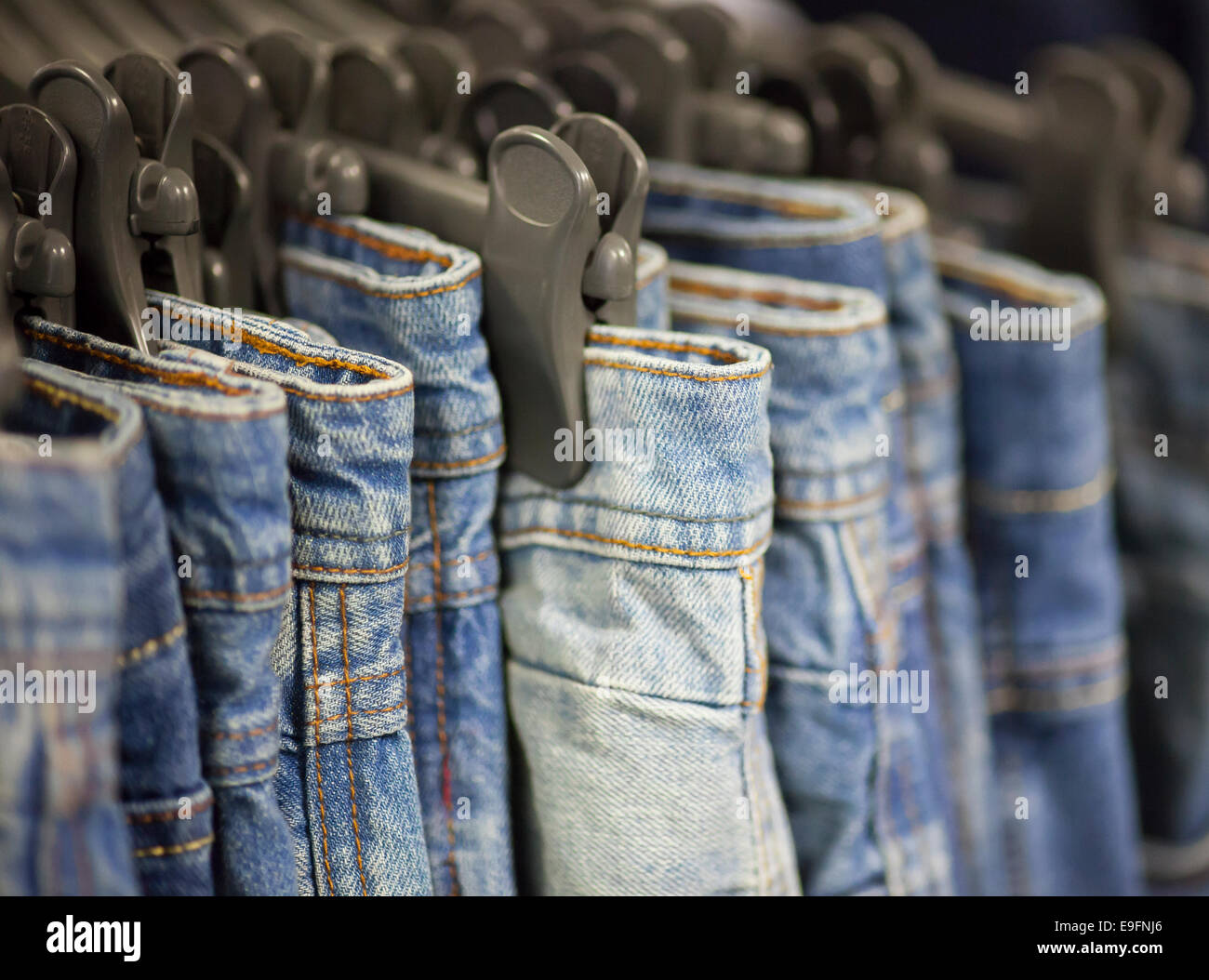 Blue Jeans on hangers in the store Stock Photo Alamy