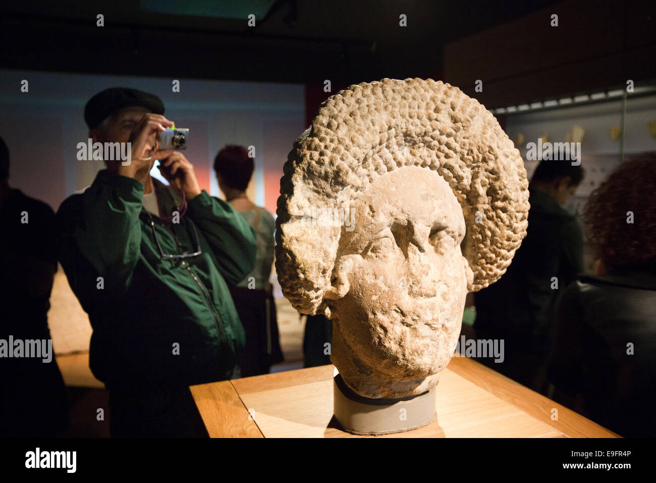 UK, England, Wiltshire, Bath, Roman Baths exhibition, visitor taking photograph of statue fragment Stock Photo