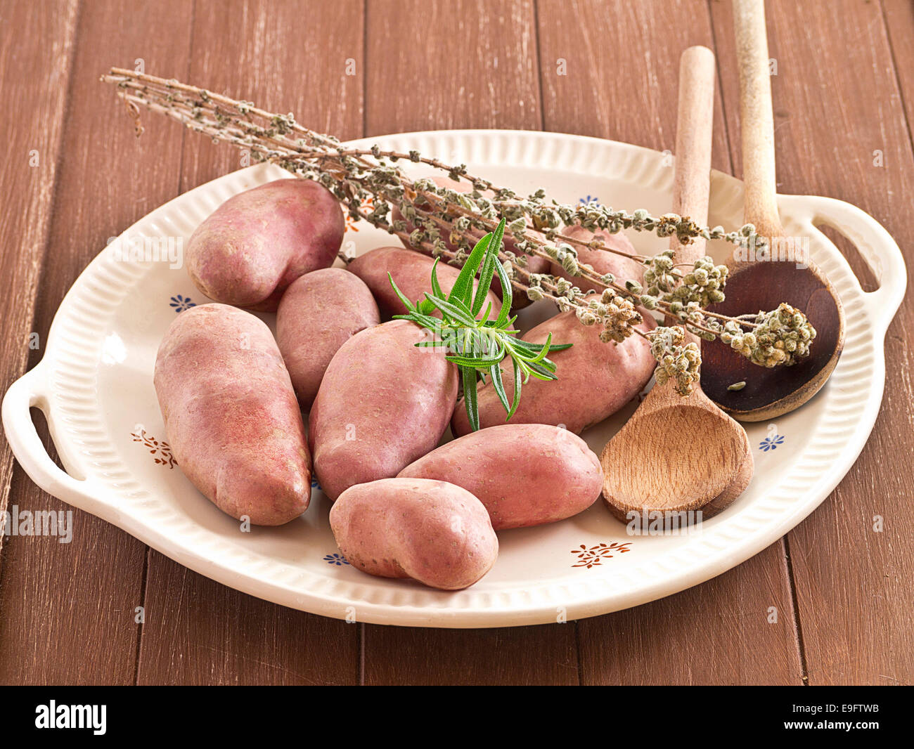 Uncooked potatoes with herbs on a plate Stock Photo