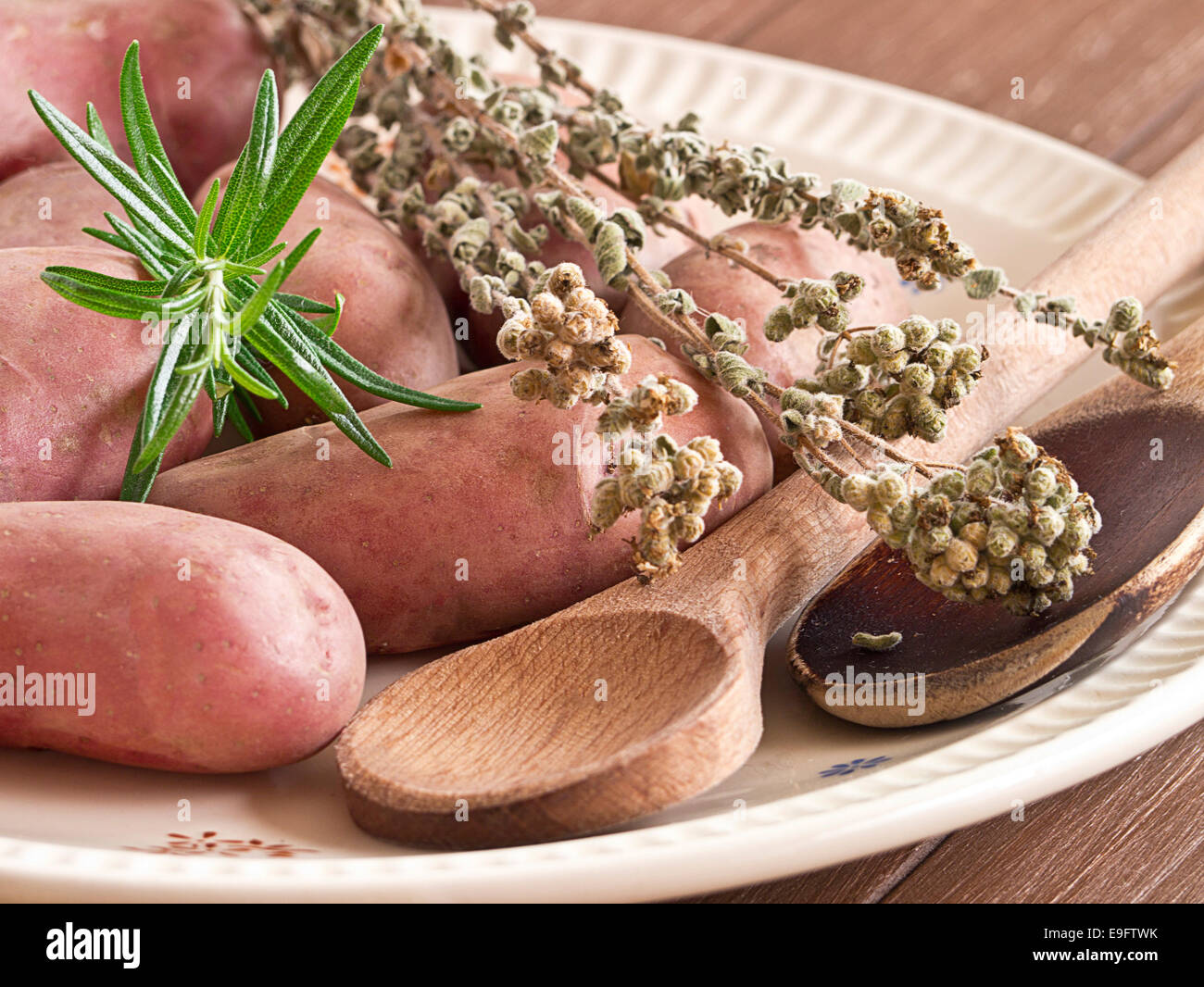 Uncooked potatoes with herbs on a plate Stock Photo