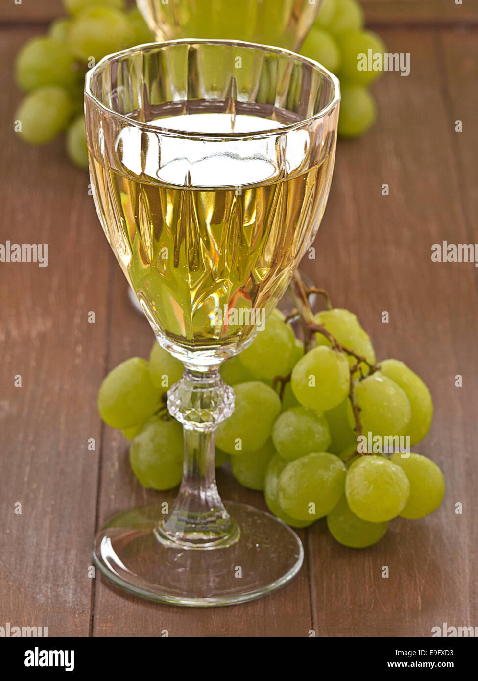 A glass of white wine with grapes Stock Photo