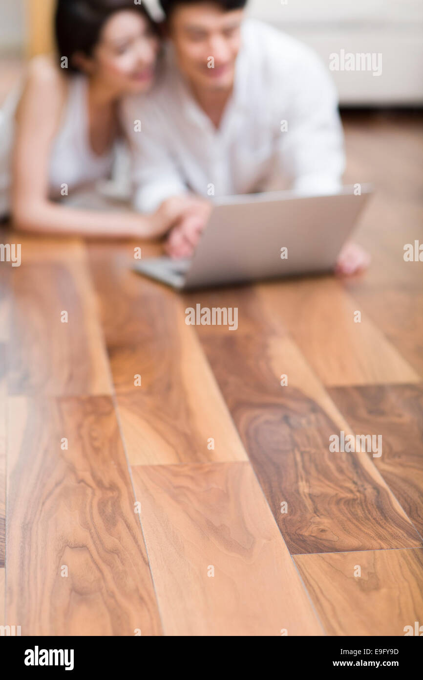 Young couple lying on floor using laptop Stock Photo - Alamy