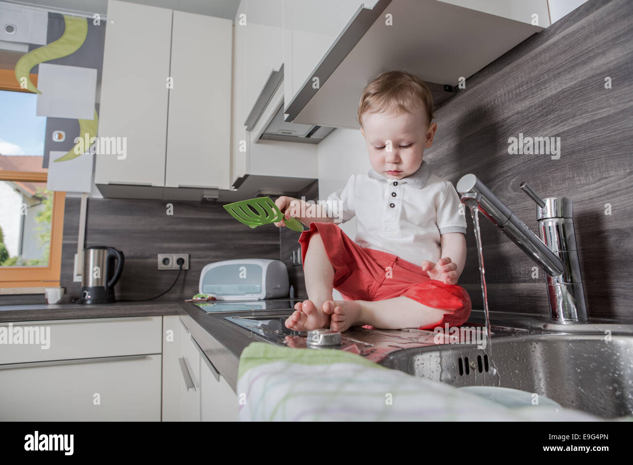 a 1,5 years old boy playing in the kitchen Stock Photo Alamy