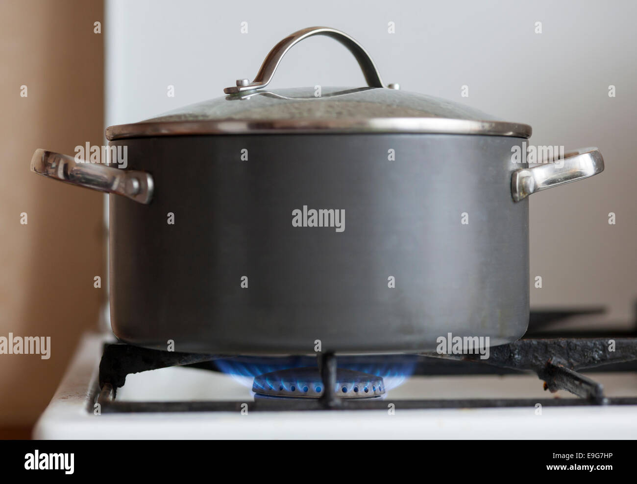 Pot with cover on flame burning of old gas cooker Stock Photo Alamy