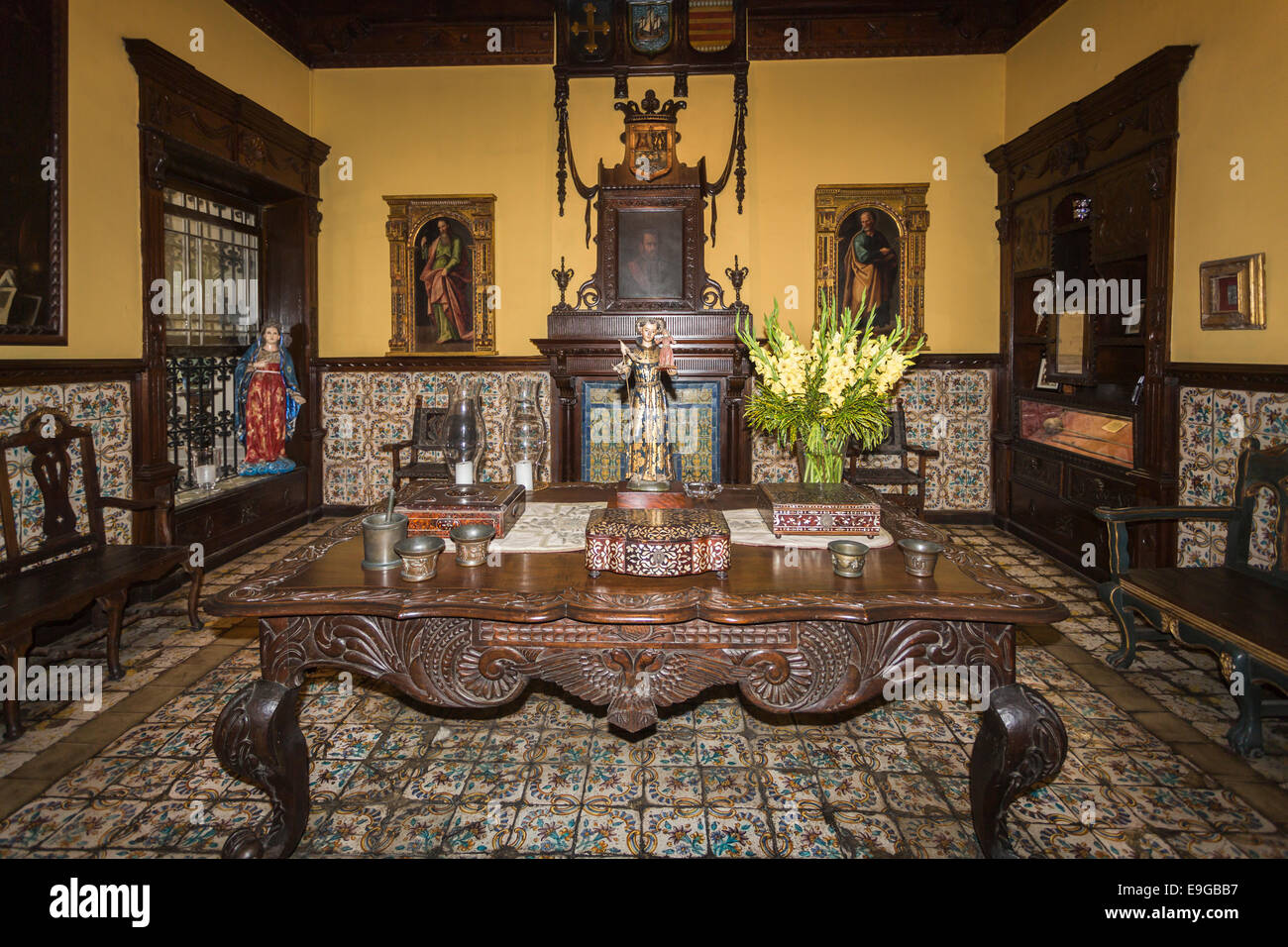 Tiled Room with wooden dining table and paintings in the historic colonial house, Casa Solariega de Aliaga, Lima, Peru, home of Francisco Pizarro Stock Photo